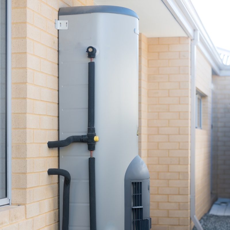 Rheem Hot Water System installed on exterior brick wall of a residential property.