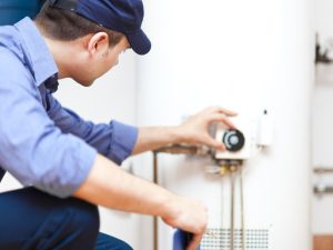 An expert inspects a hot water tank to determine if it's time to replace it.