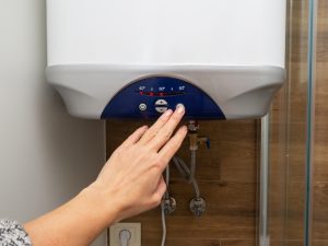 Hand adjusting a hot water system after suspected hot water system repair due to a strange noise.