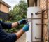 Plumber inspecting a hot water unit for leaks and wear to decide whether repair or replacement is needed in a Sydney home.