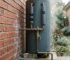 Outdoor hot water unit with insulated pipes and tempering valve installed beside a Sydney home in winter.