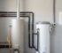 Gas and electric hot water systems installed side by side in a clean residential utility area for a maintenance comparison.